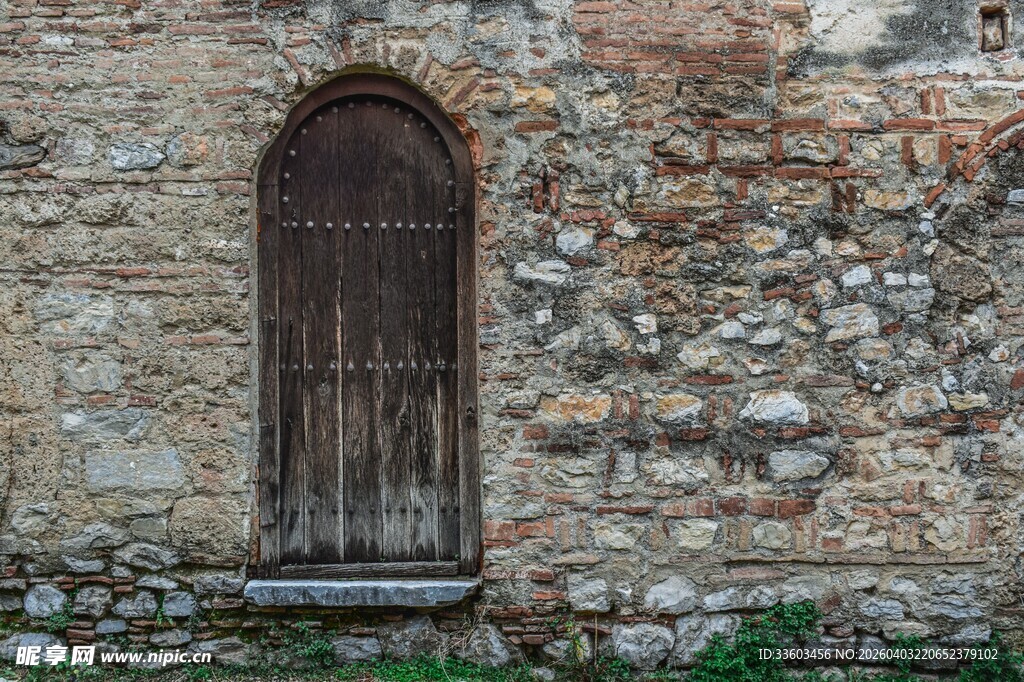 古老石墙中的木质拱形窗