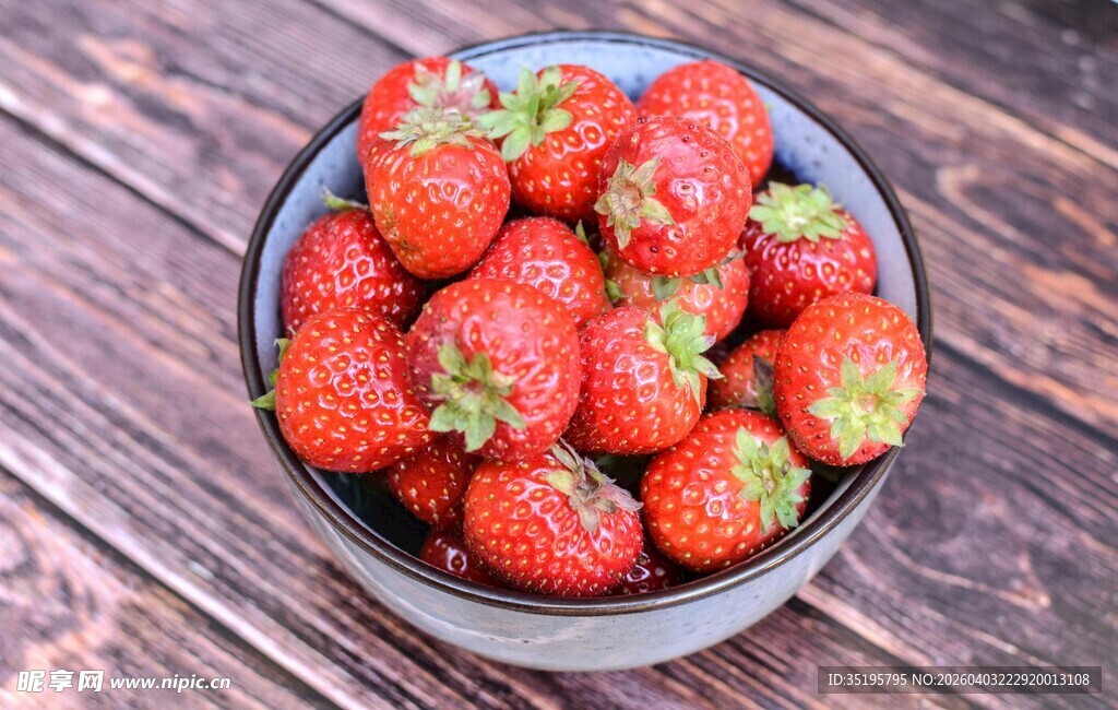 木桌上碗中新鲜的草莓