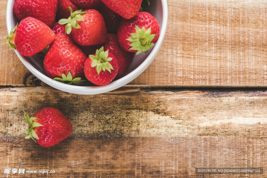 木桌上碗装新鲜草莓