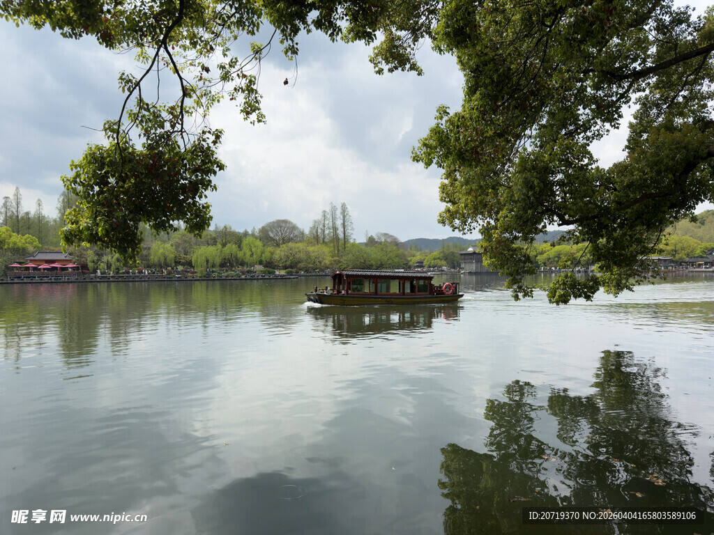宁静湖畔小船伴绿树倒影