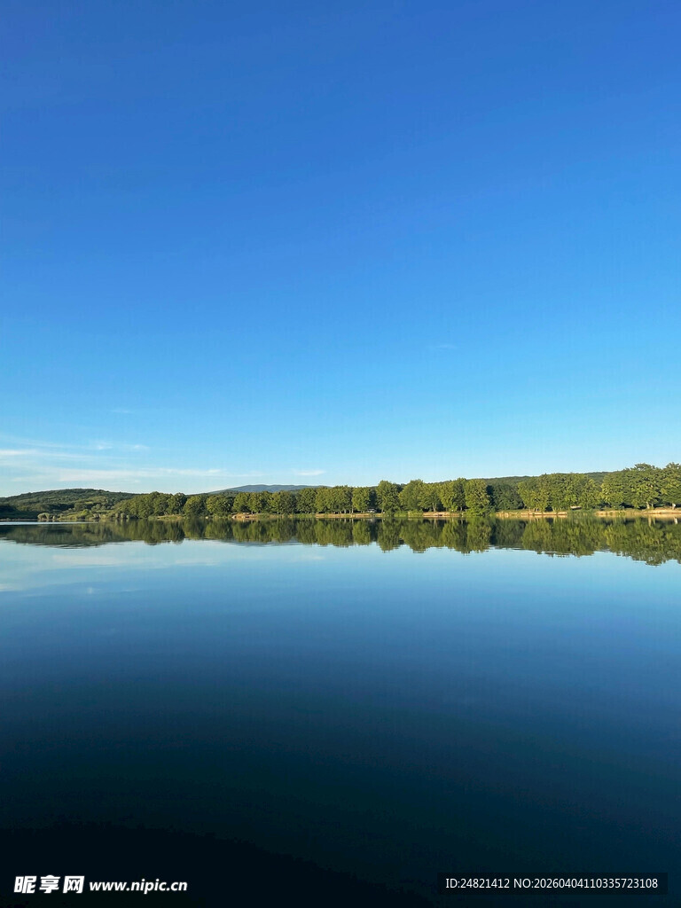 宁静湖面与蓝天绿树倒影