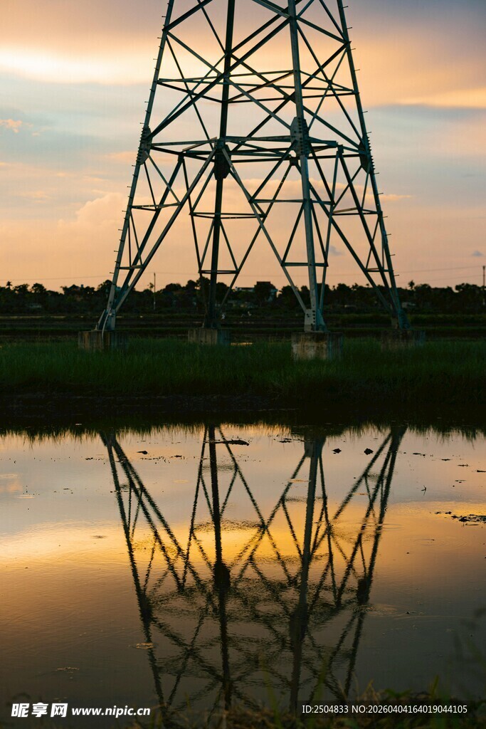 夕阳下的输电塔与水面倒影