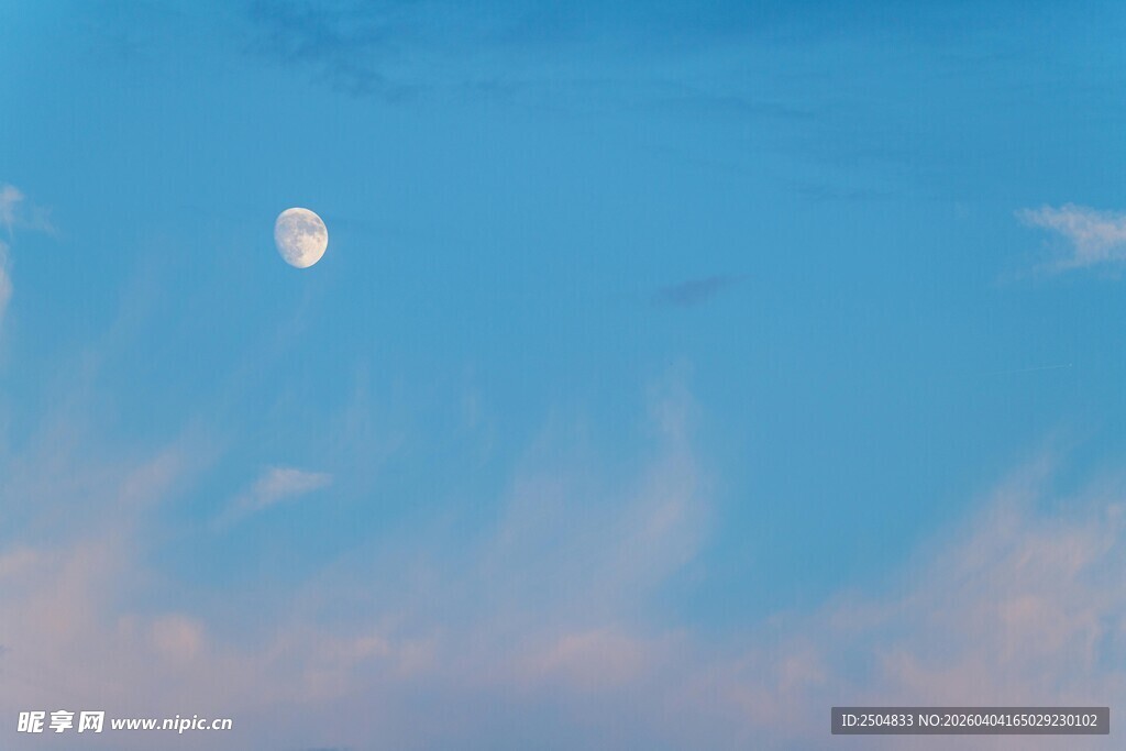 蓝天下的月亮与轻柔云彩