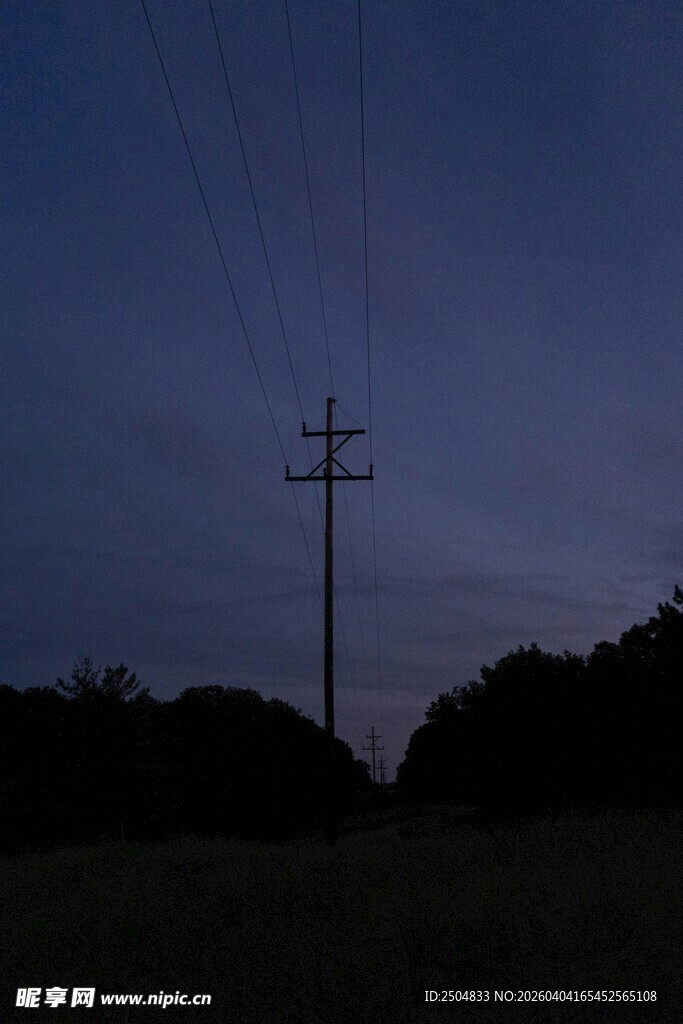 黄昏田野中的电线杆剪影