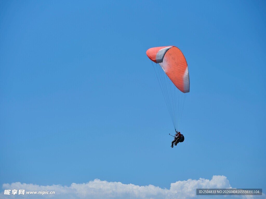 空中滑翔的橙色滑翔伞