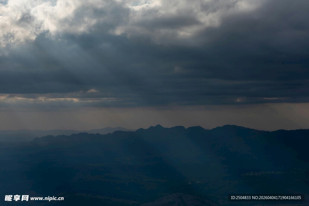 乌云下穿透光芒的山峦