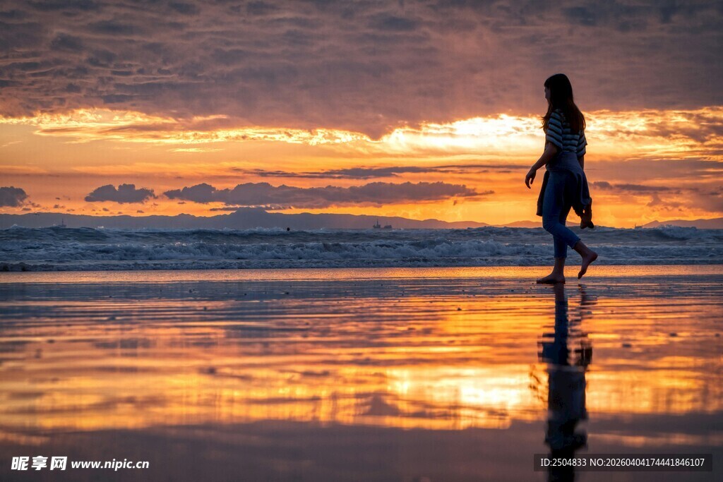 夕阳下海边漫步的孤独身影