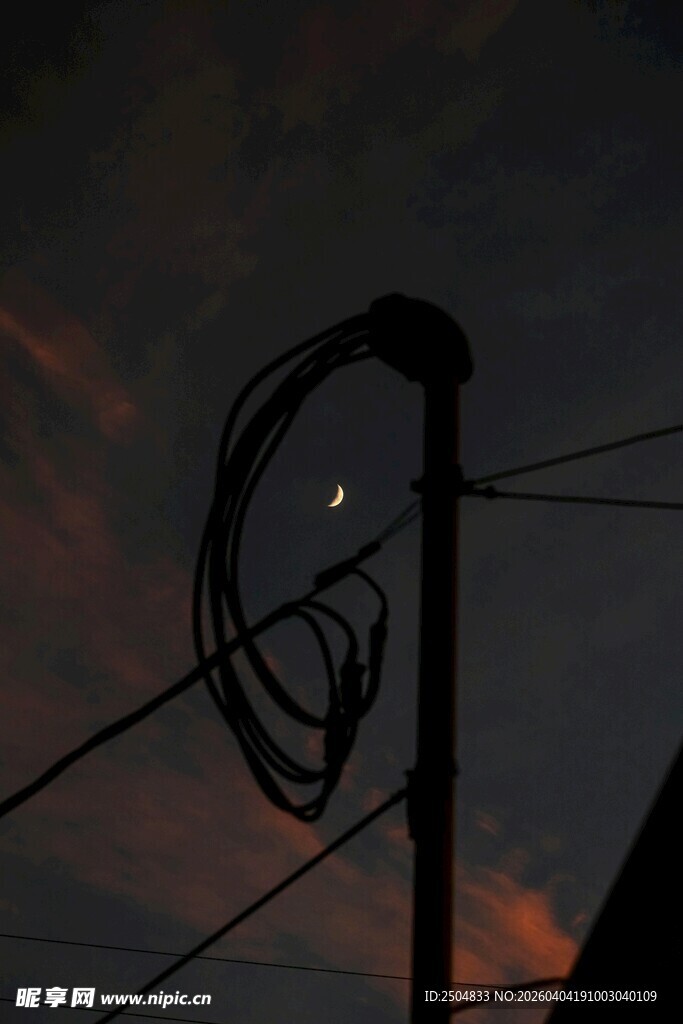 暮色中缠绕的电线与弯月
