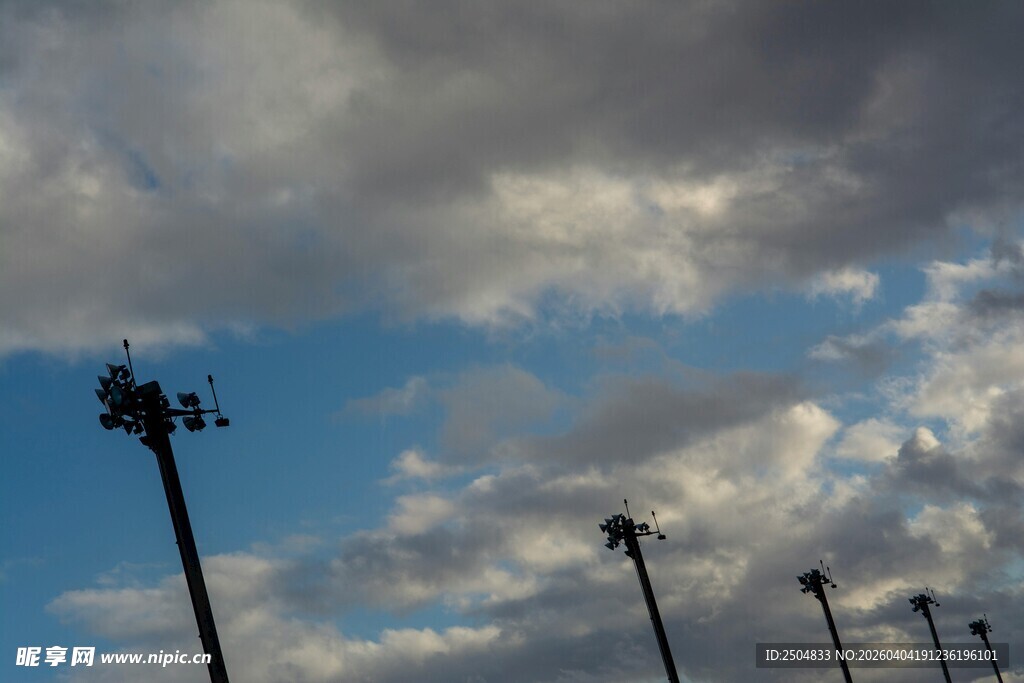 蓝天乌云下的高耸灯杆