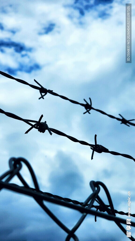 带刺铁丝网与蓝天背景