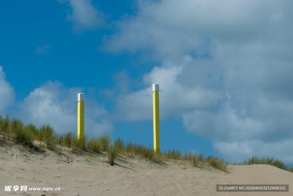 沙丘上的两根黄色标志杆