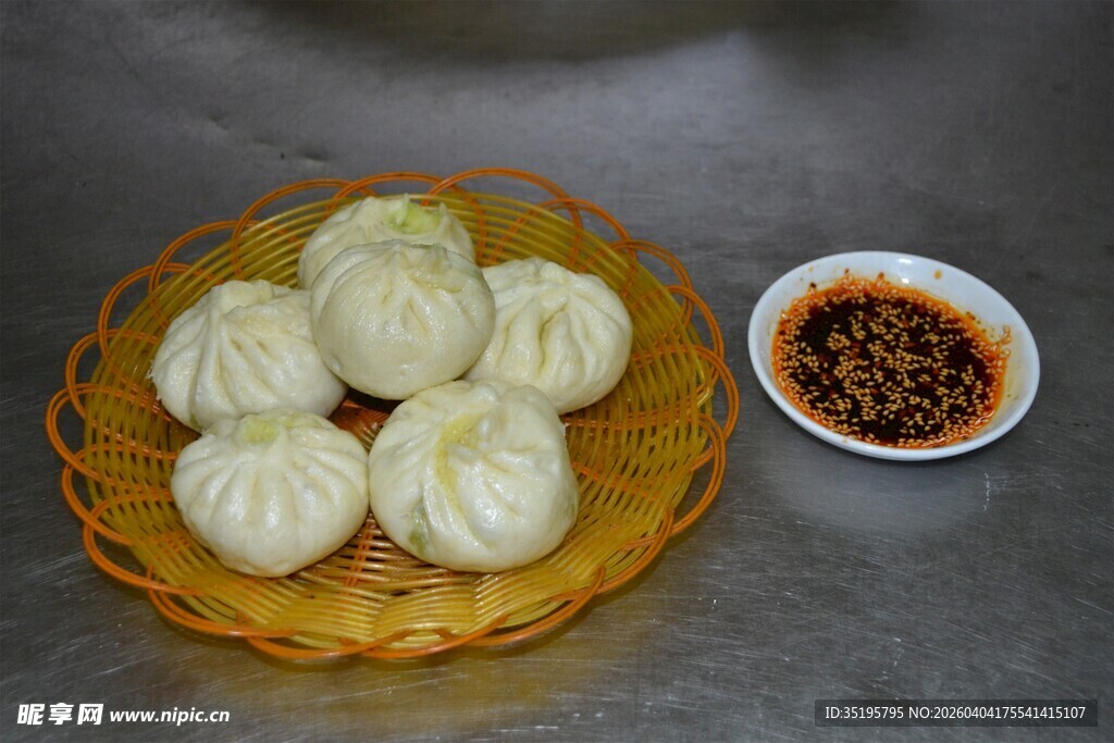 竹篮中的美味包子及蘸料