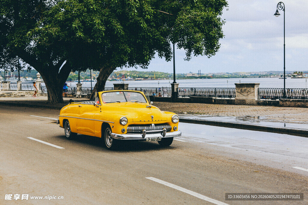 复古黄车行驶在海滨道路