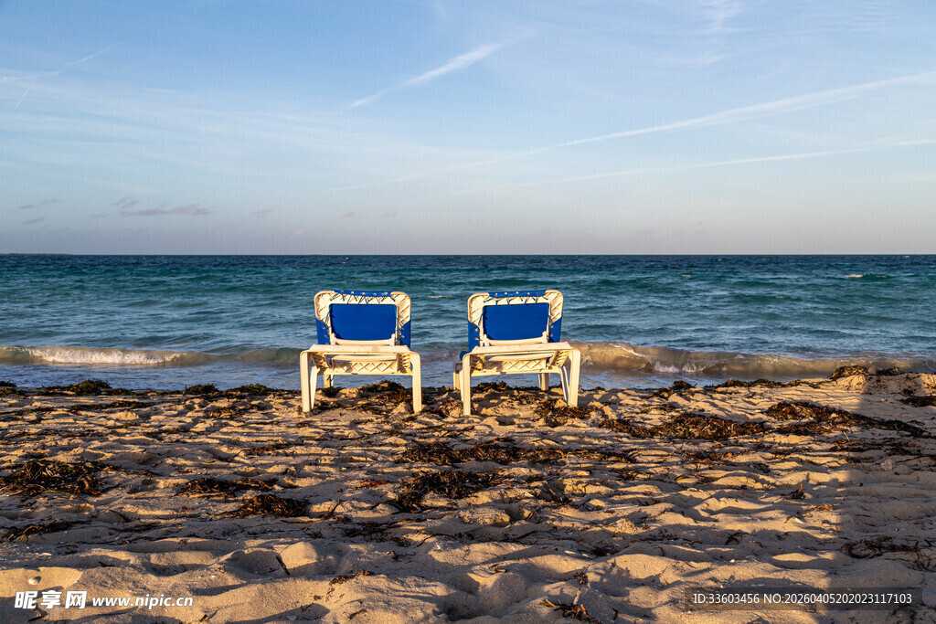 海边沙滩上的两把休闲躺椅