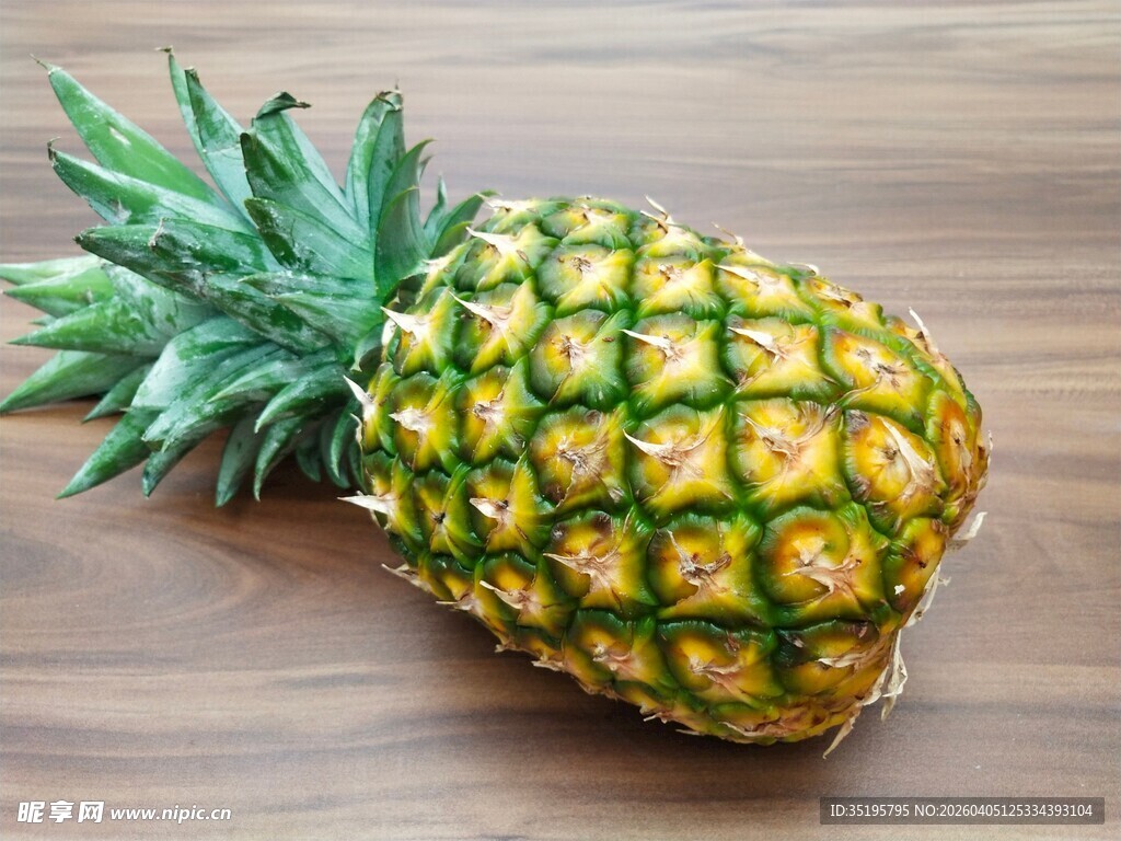 新鲜菠萝置于木质桌面上
