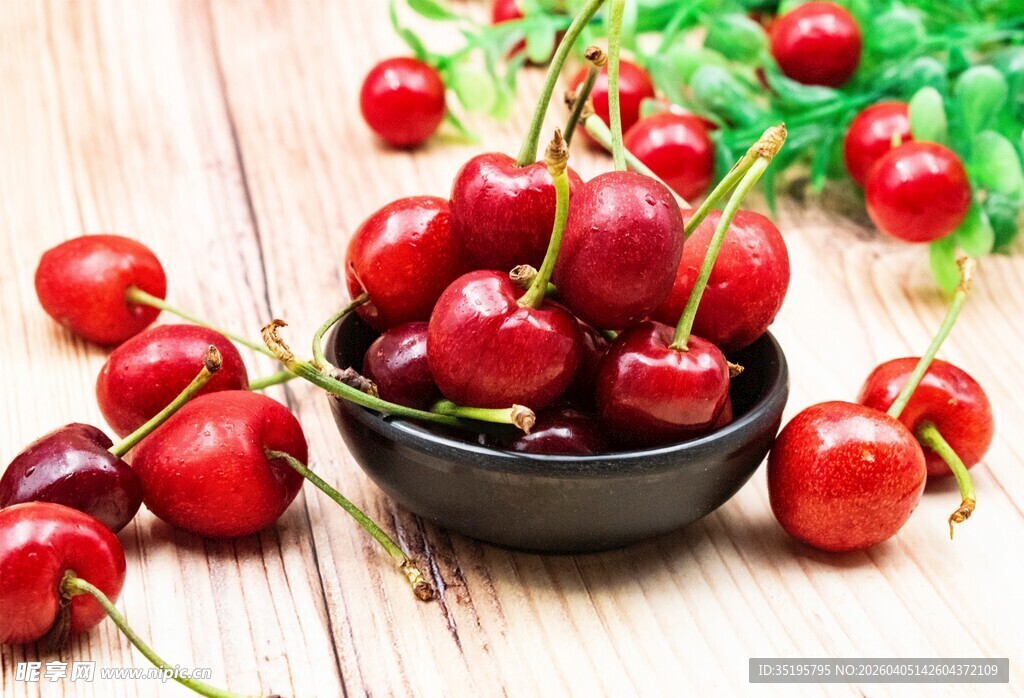 木桌上黑碗中的新鲜樱桃