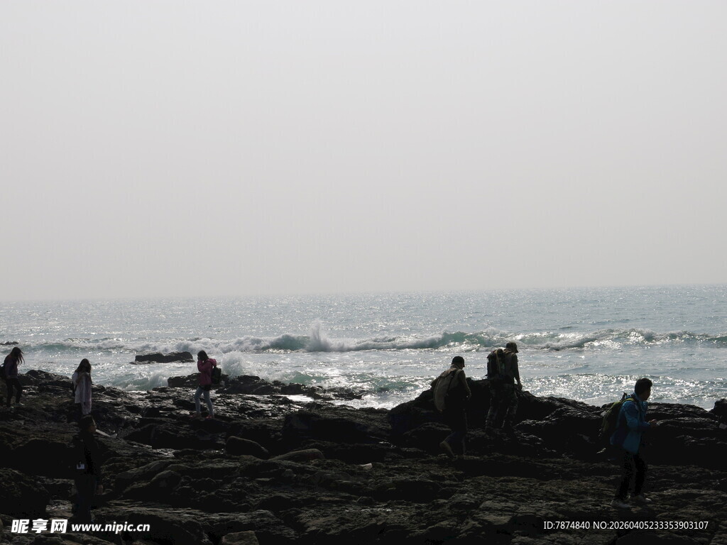 海边礁石上的漫步身影