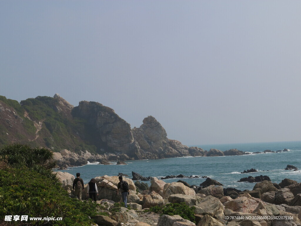 海岸边嶙峋岩石与青山海景