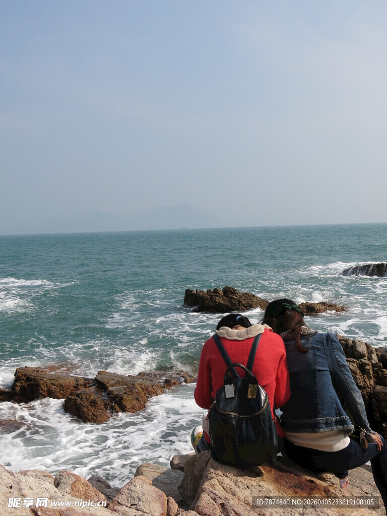 海边礁石上的背包旅行者