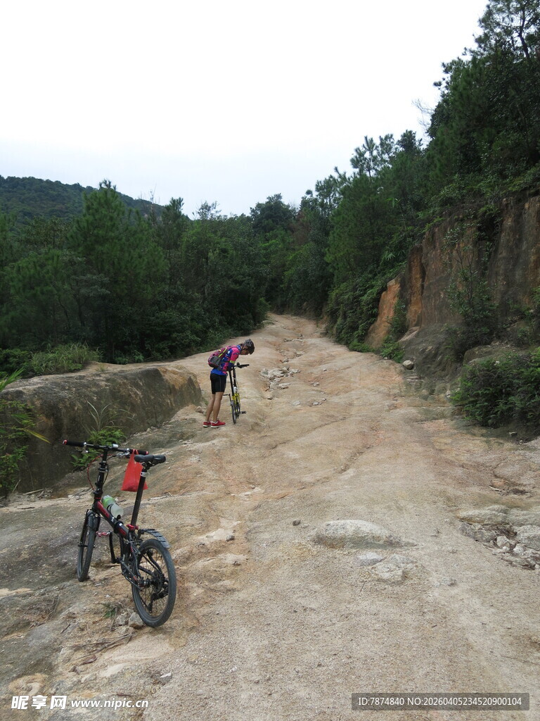 山地骑行者沿土路前行