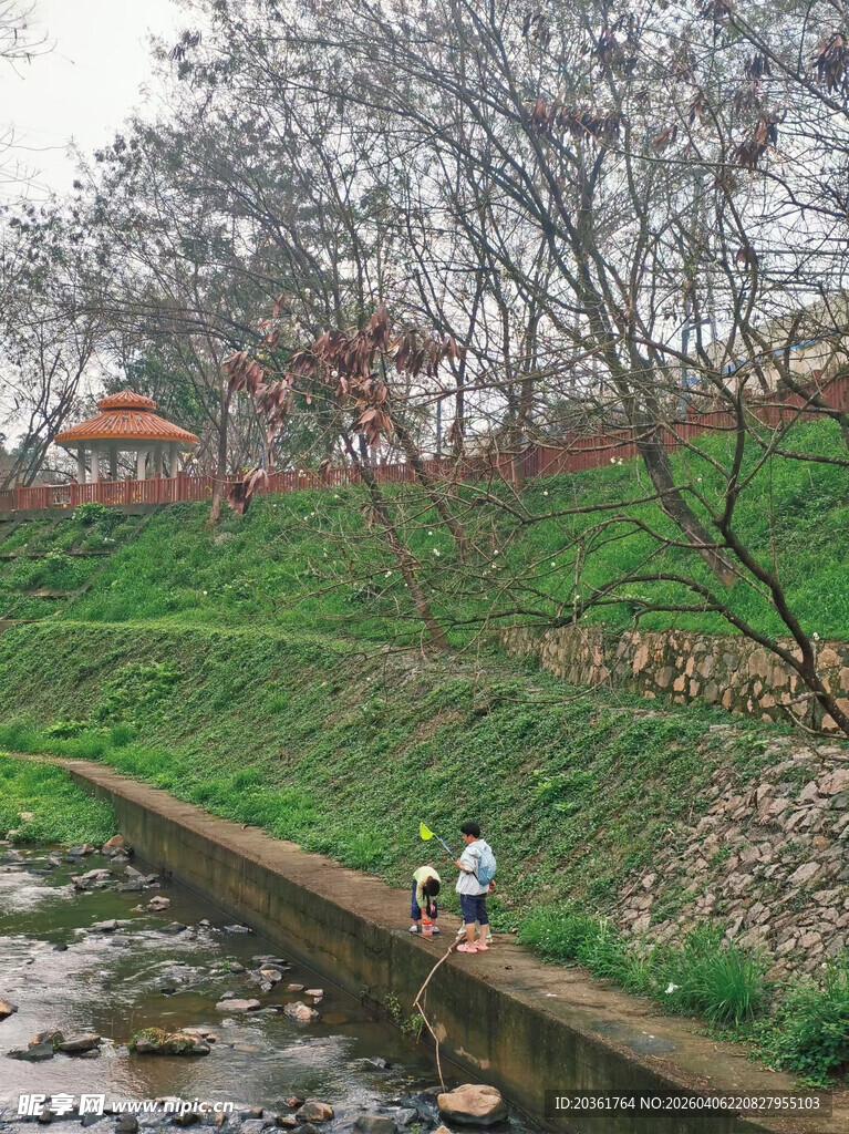 溪边孩童玩耍的春日景致