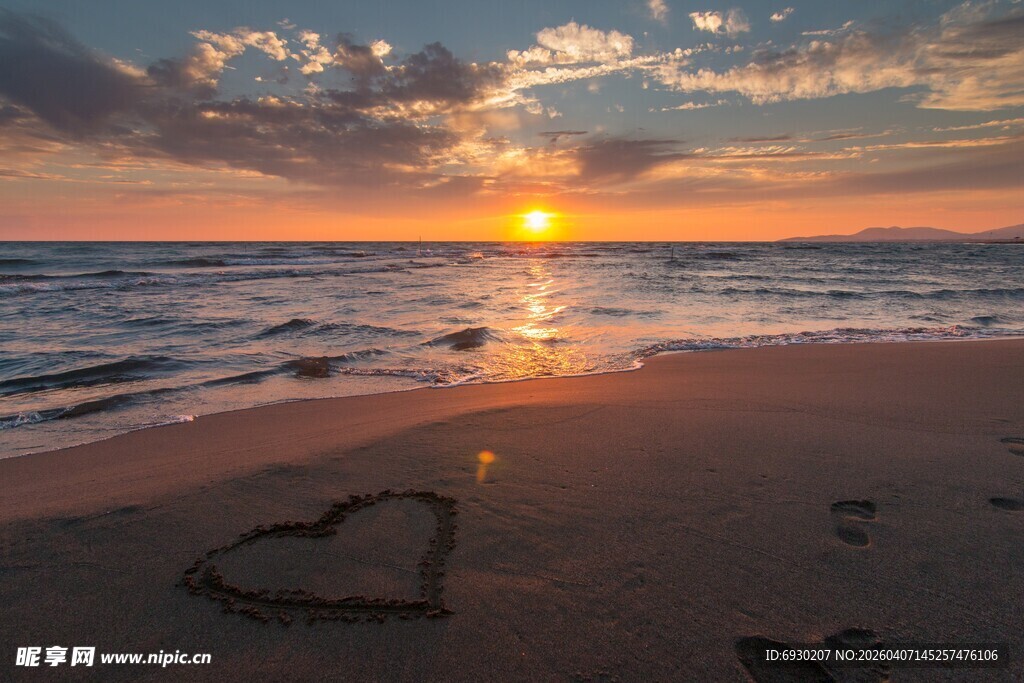 海边日落沙滩上的心形印记