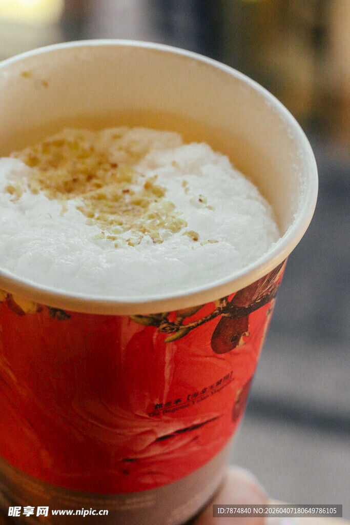 手持红色纸杯装的咖啡