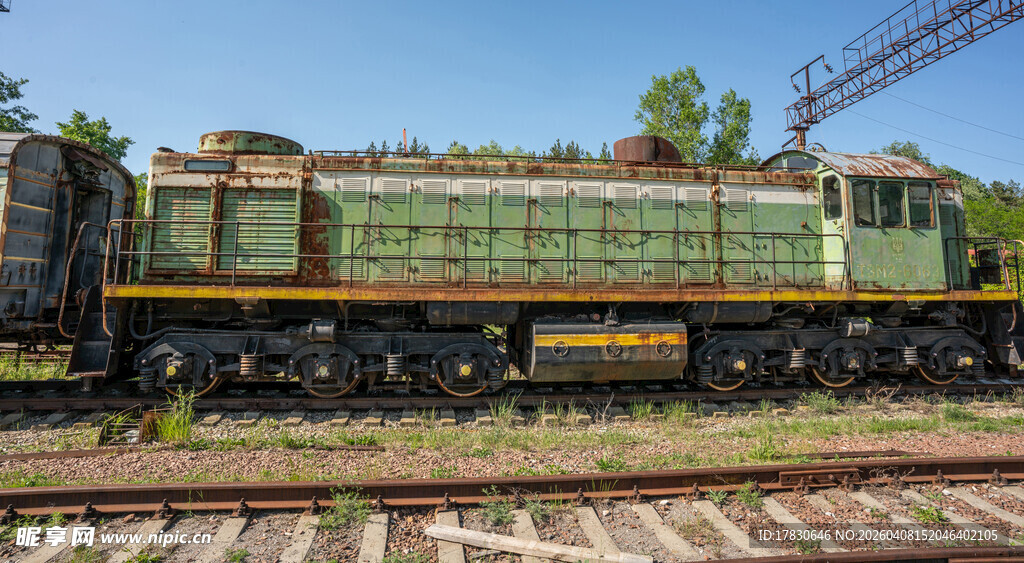 老式绿色火车头停在铁轨上