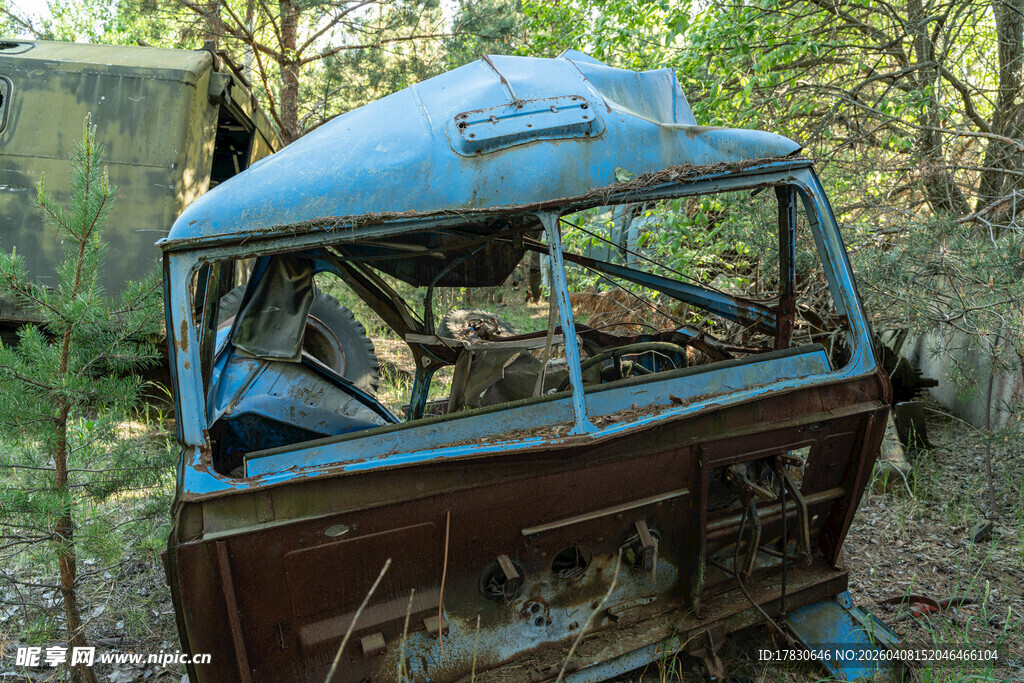 废弃森林中的破旧蓝色汽车