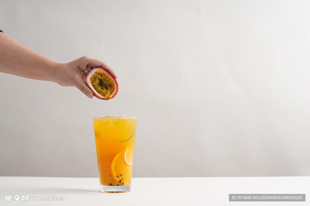 手挤百香果入橙汁饮品