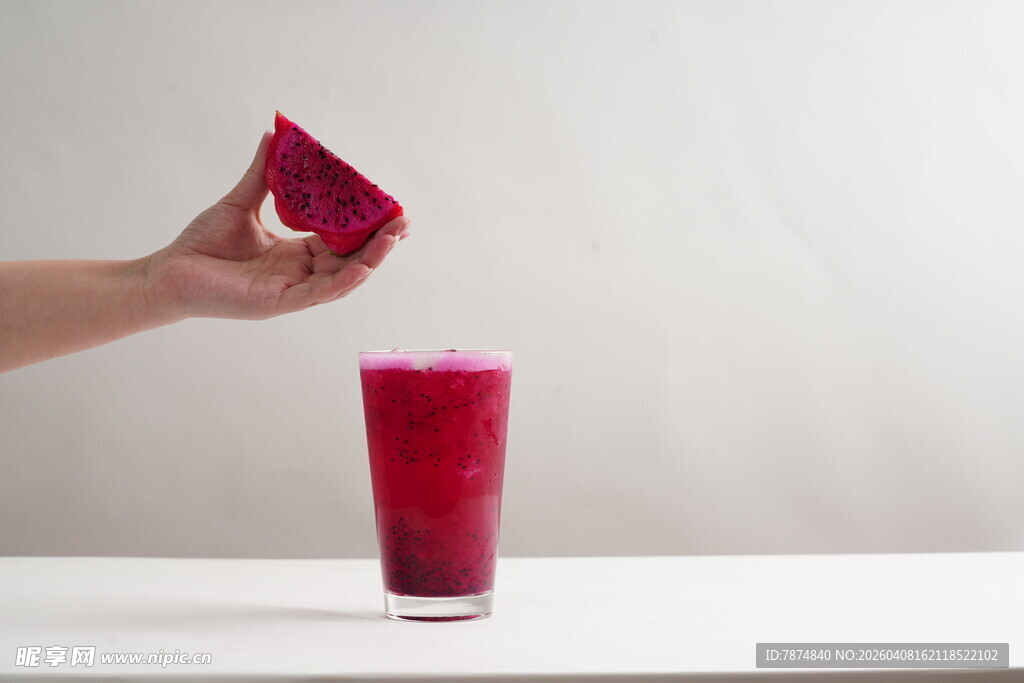 手倒红色果汁入玻璃杯