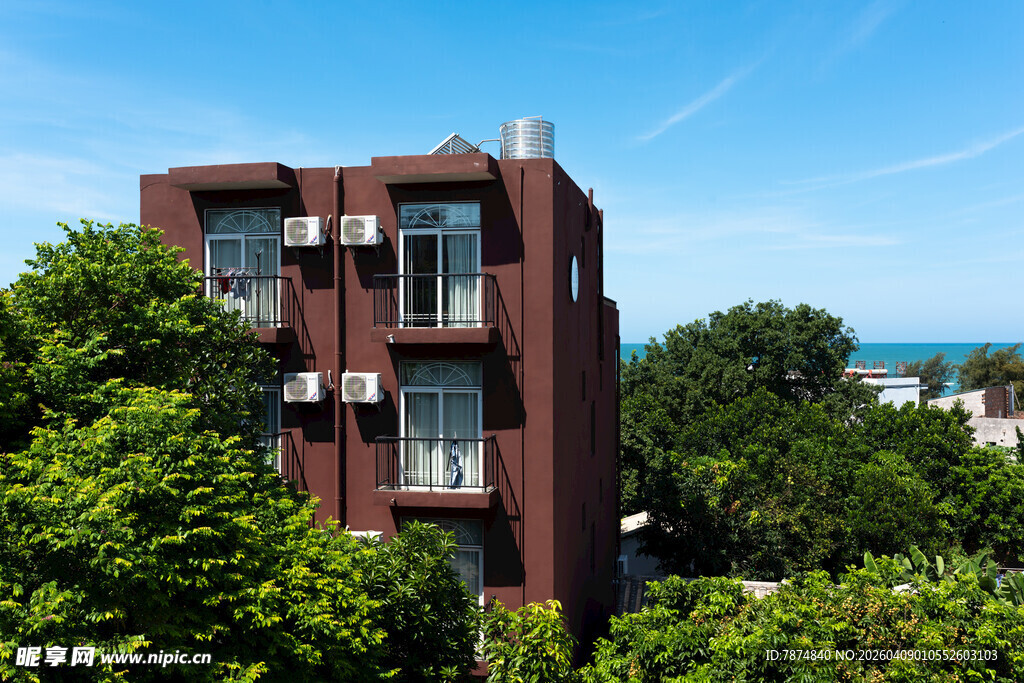 红砖楼房隐于绿树蓝天间