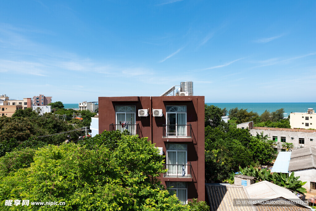 红砖建筑旁绿树与海景