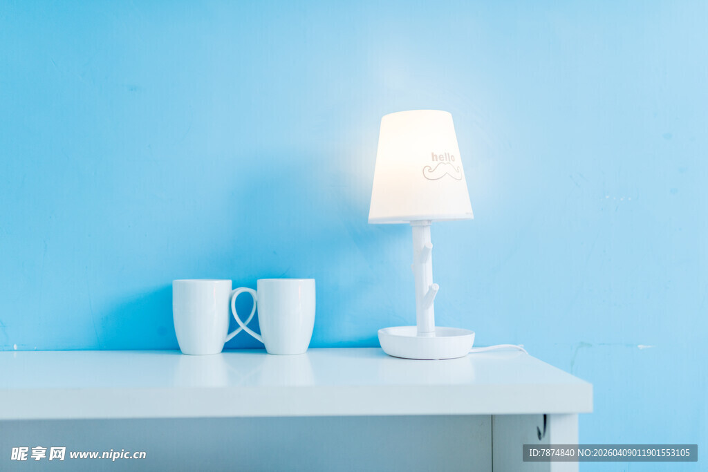 蓝墙下的简约台灯与杯子