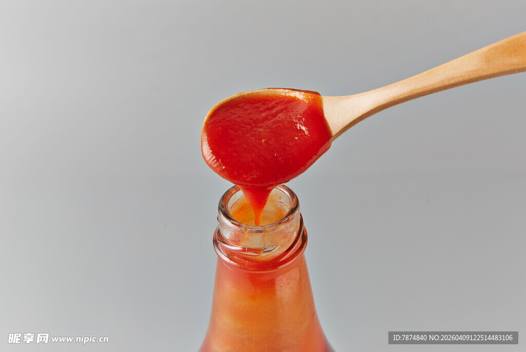 木勺舀番茄酱正倒入瓶中