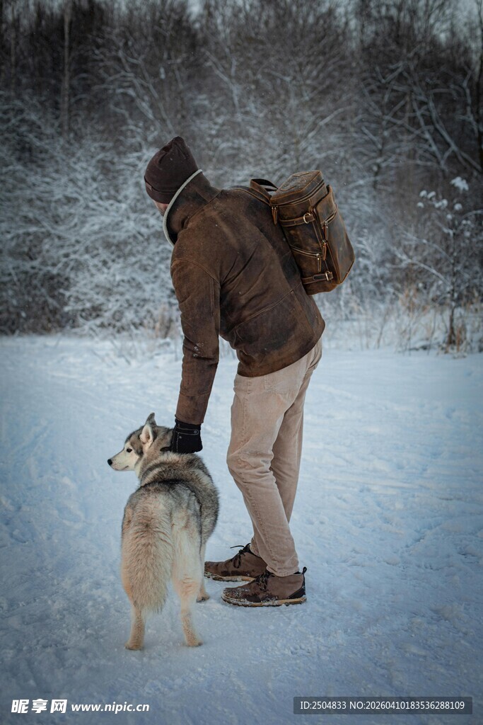 雪地中人与两犬温馨相伴