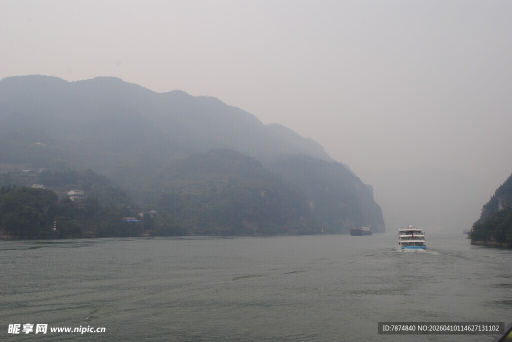 江上雾景中的船只与山峦