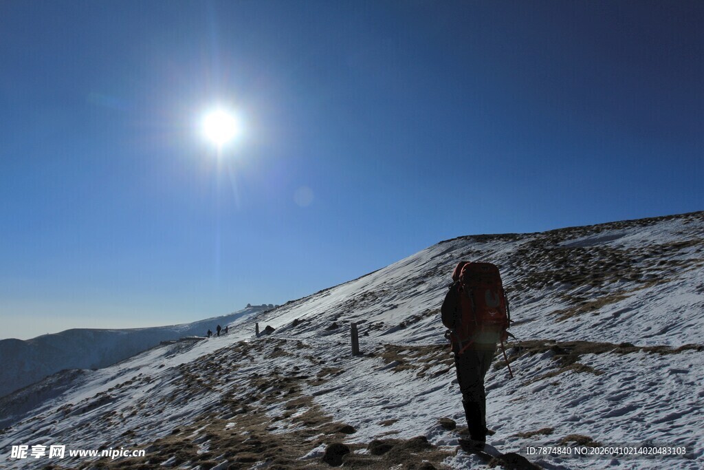 徒步者于雪山向阳而行
