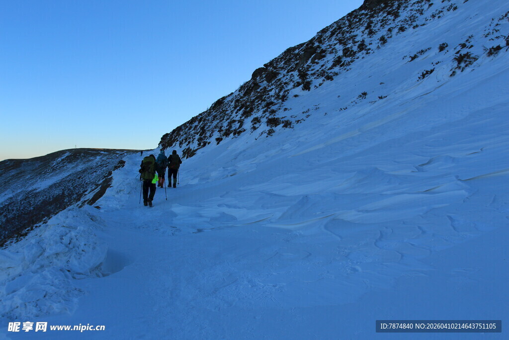 雪地徒步者攀登陡峭山坡