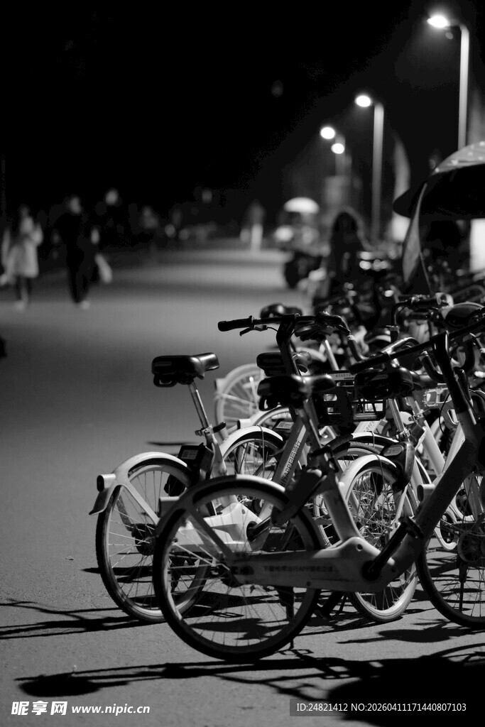 夜晚街边停放的一排自行车