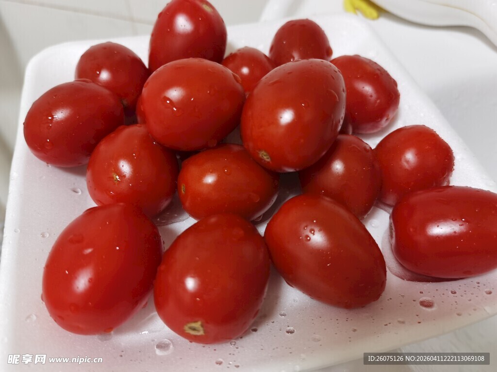 新鲜圣女果摆放在白色盘中