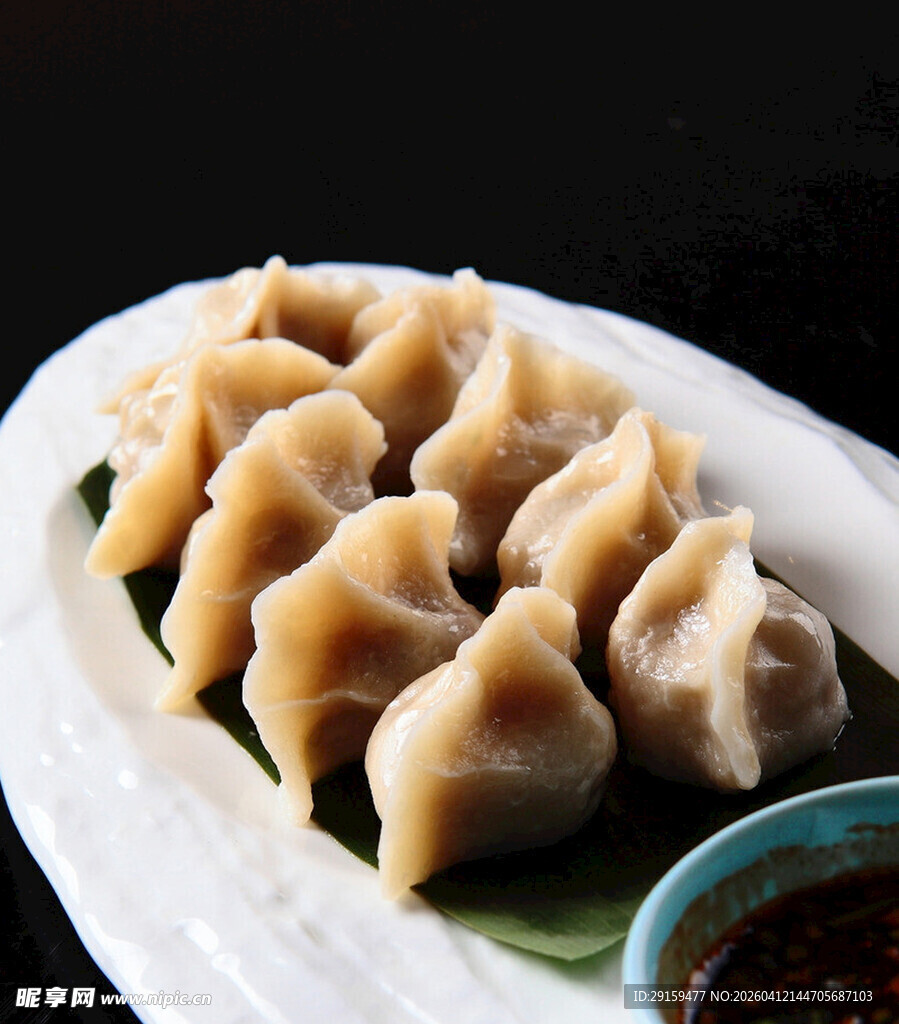 美味饺子摆放在盘蘸料旁