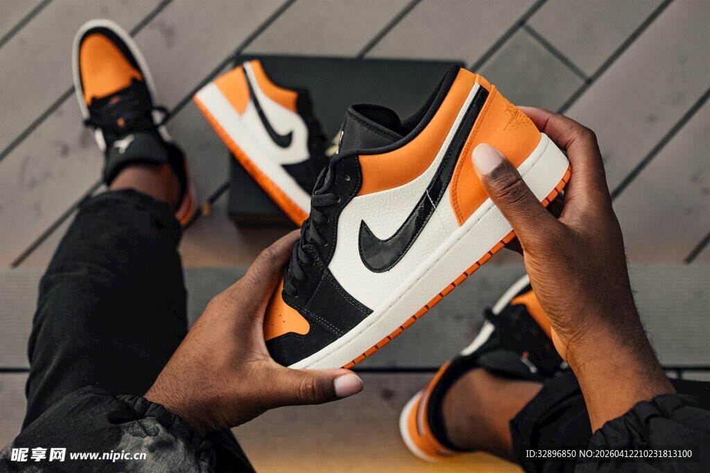 潮流人士展示橙黑运动鞋