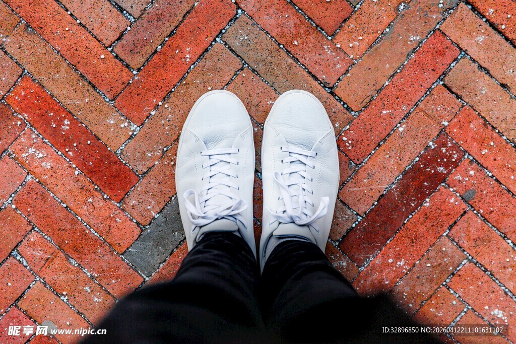 白色运动鞋立于红砖地面