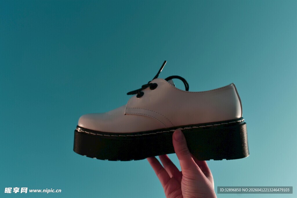 手举厚底白色皮鞋