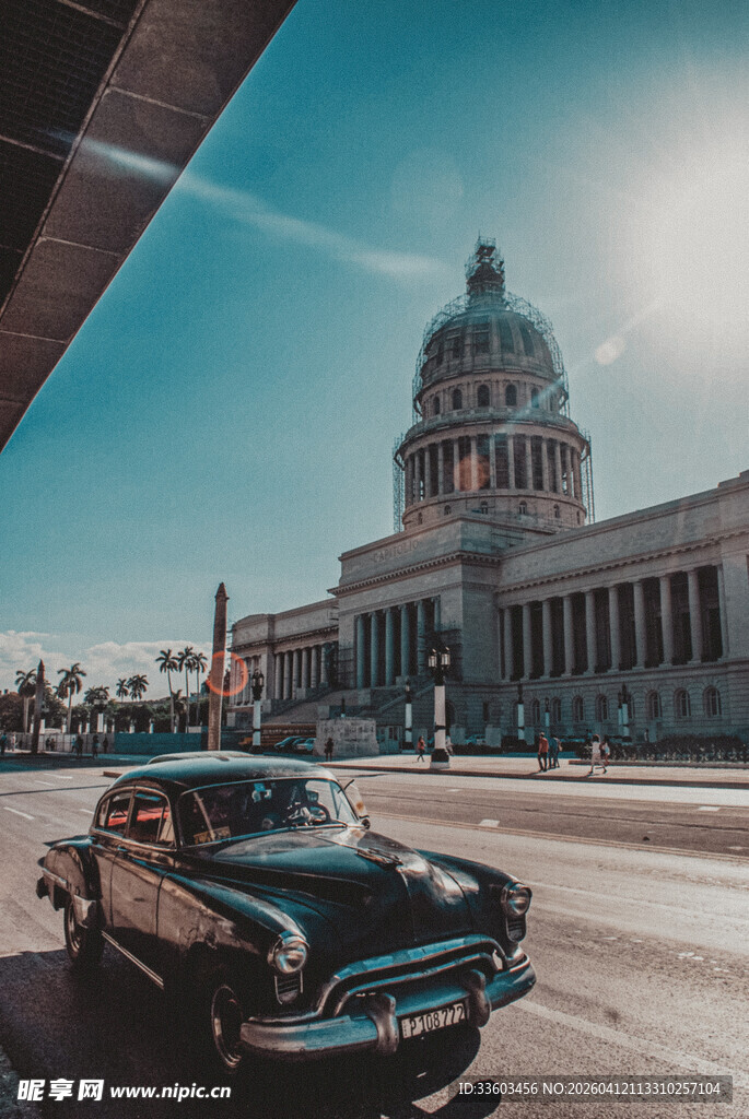 复古汽车驶过宏伟建筑