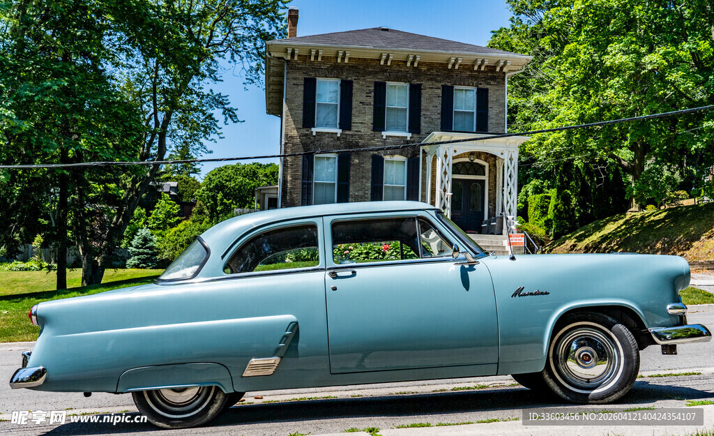 复古蓝车停于绿荫美宅前