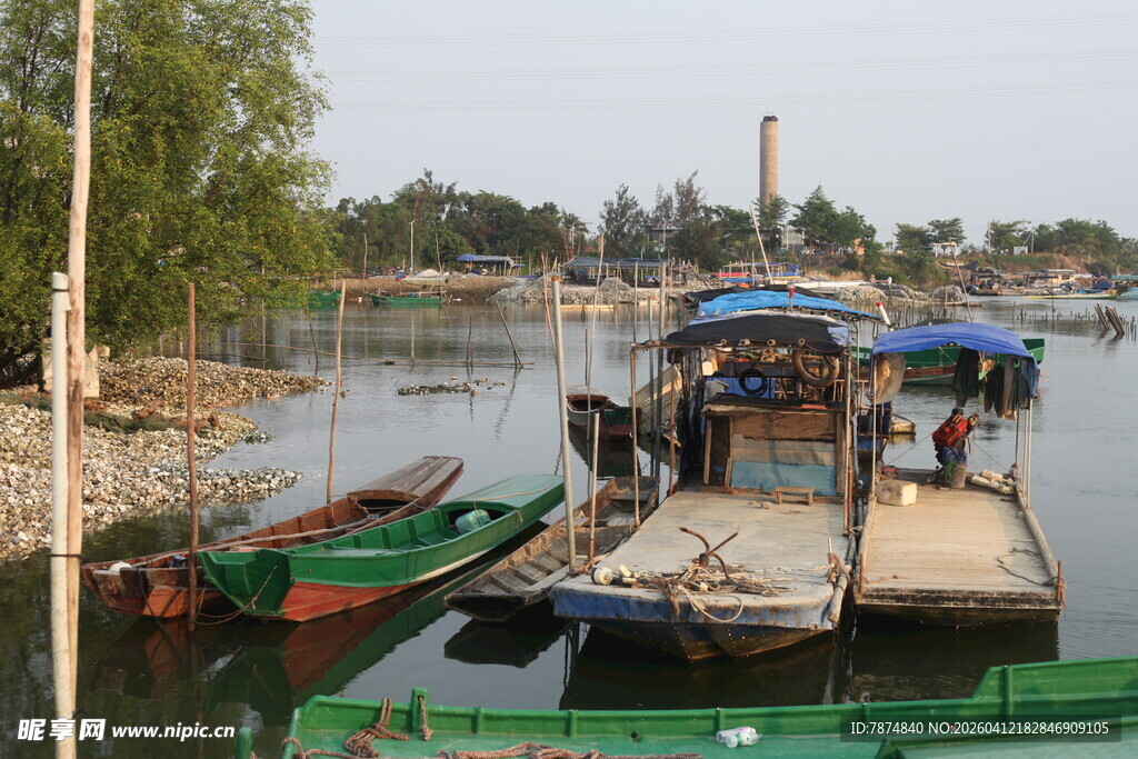 湛江宁静河畔停泊的多彩船只