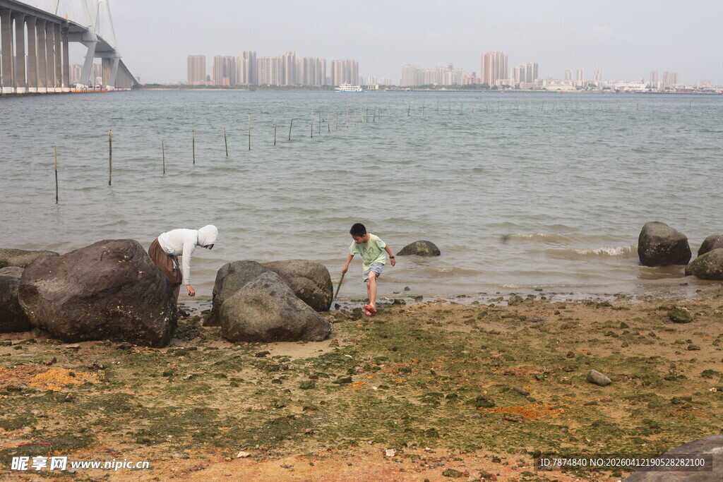 湛江海边孩童嬉戏于礁石旁