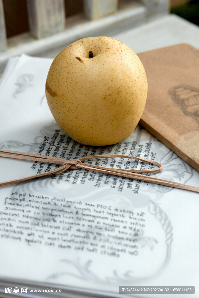 梨置于古籍上的雅致画面